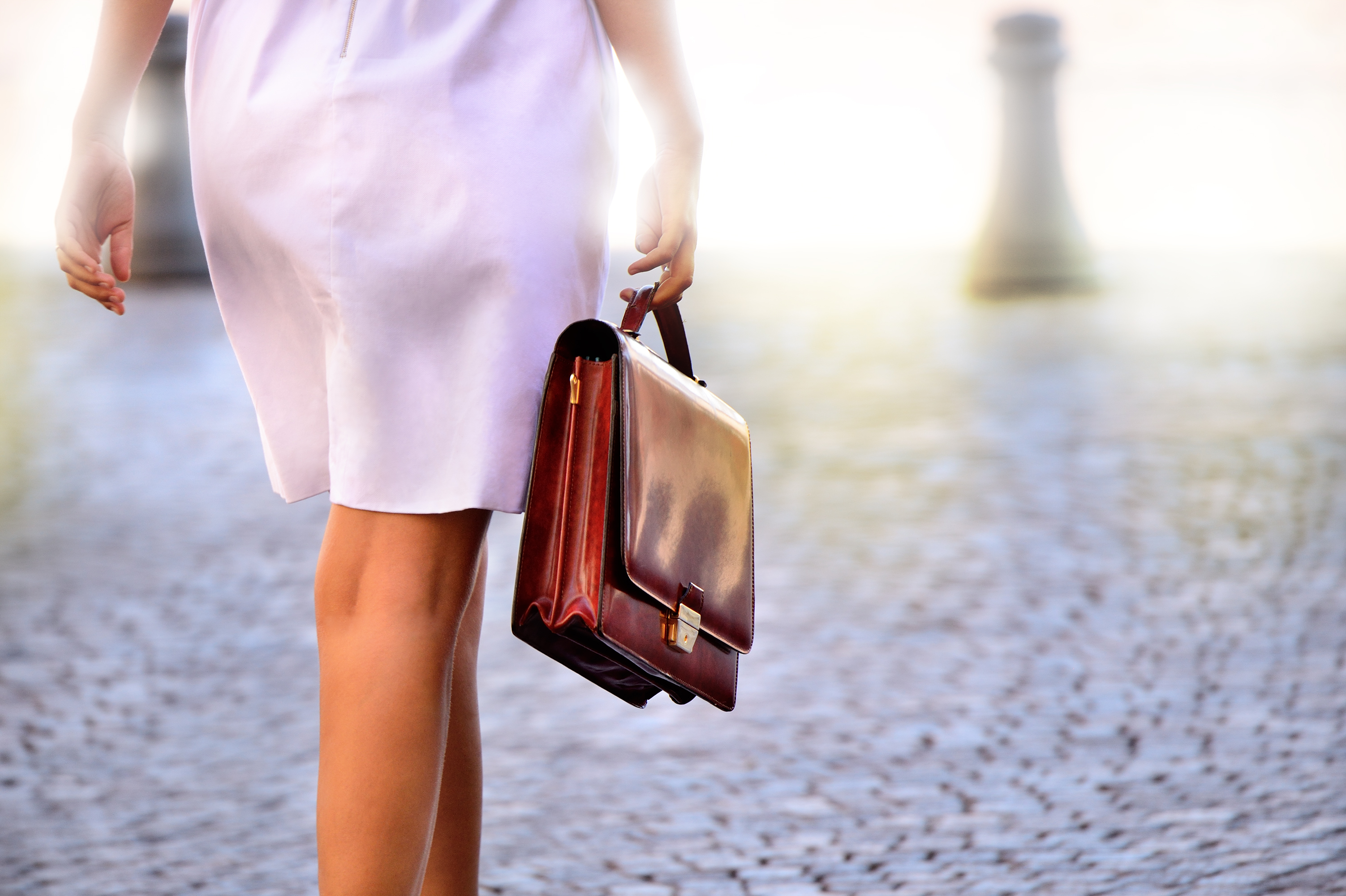 Woman in skirt walking with briefcase