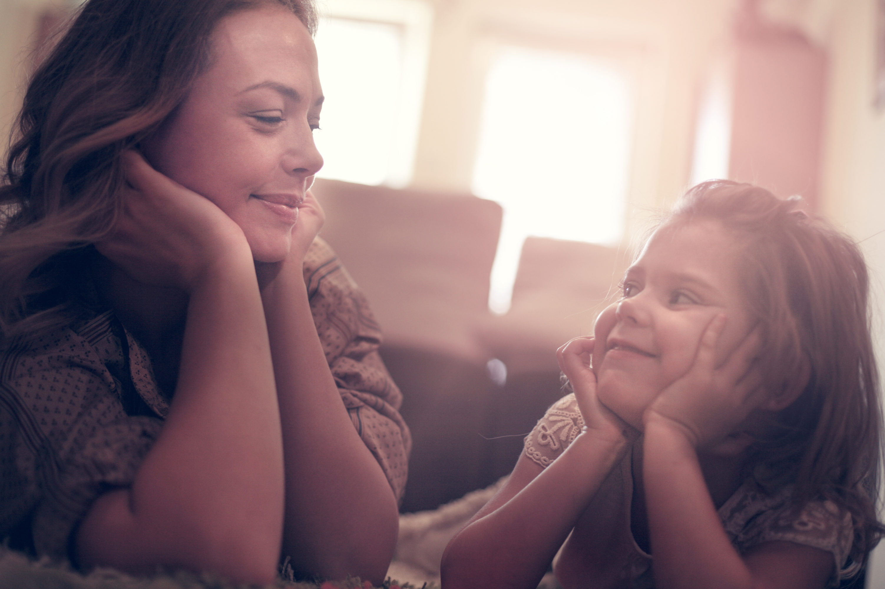 Mother and young girl smiling at each other